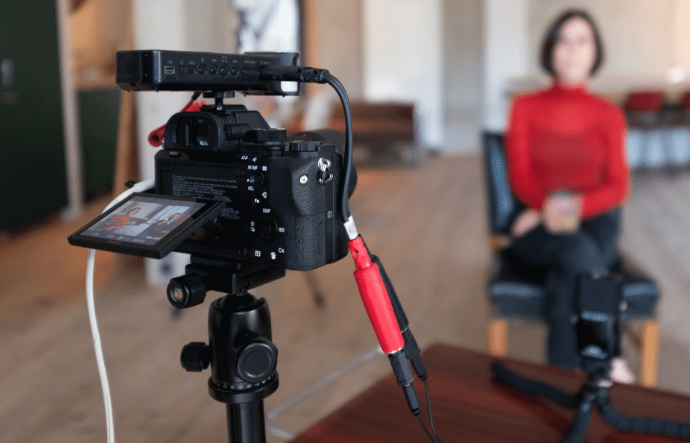 Camera setup recording a woman in a red top, creating content for an online business or social media.